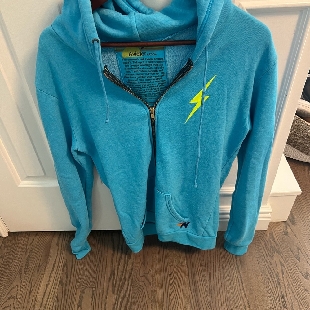 Aviator Nation zip up hoodie in turquoise, size Medium with Neon bolt on back.